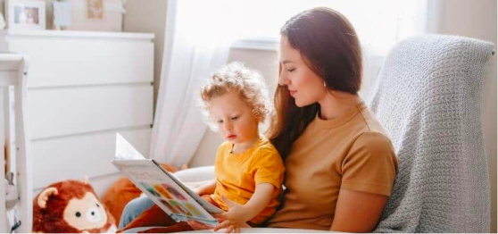 Mujer joven le lee a su hijo pequeño